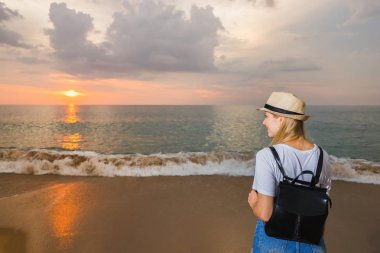 Sırt çantası plaj ve zevk Günbatımı ile turist. Seyahat kavramı.
