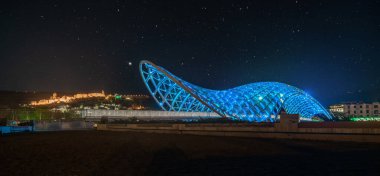 Gürcistan 'ın başkenti Tiflis' teki Kura Nehri üzerindeki Barış Köprüsü. Gece fotoğrafı. Pankart sürümü.