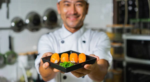 Smiling asian chef with sushi. Banner edition. Selective focus.