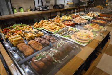 Farklı yemeklerle servis edilen açık büfe masası, balıklar, et ve diğer şeyler restoranda yemek için hazır. Seçici odak.