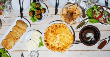 Geleneksel Gürcistan yemeklerinin olduğu masadaki manzara: hachapuri, egplant, kupati, salata, peynir, mchadi. Seçici odak.