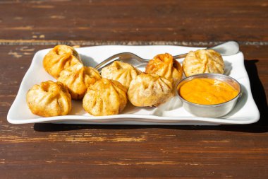 Soslu geleneksel kızarmış nepali momo tabağı. Yaklaş, seçici odaklanma.