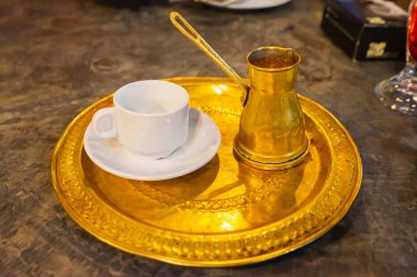 Kahve hindi ve fincan tepside, arka planda ahşap masa. Seçici odak.