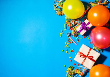 Mutlu yıllar ve tatil konsepti. Mavi arka planda hediye kutuları ve tatil aksesuarları. Kopyalama alanı olan üst görünüm. Düz yatıyordu.