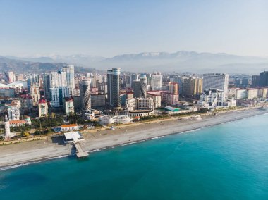 Sahilin havadan görünüşü, arka planda gökdelenler ve dağlar olan şehir. Batumi, Georgia. Hava görünümü.