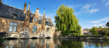 Brugge 'deki kanalda çok güzel bir ağaç ve bina var. Belçika. Pankart sürümü.
