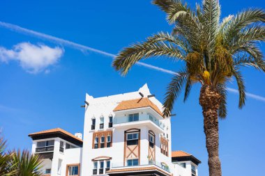 Arap tarzı ve palmiyeli apartman daireleri ve balkonları olan bir ev..