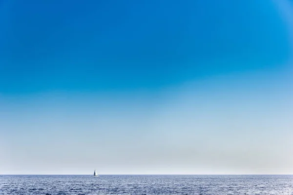 Molti cielo blu chiaro con il mare orizzontale e yacht bianco in lontananza . Immagine Stock