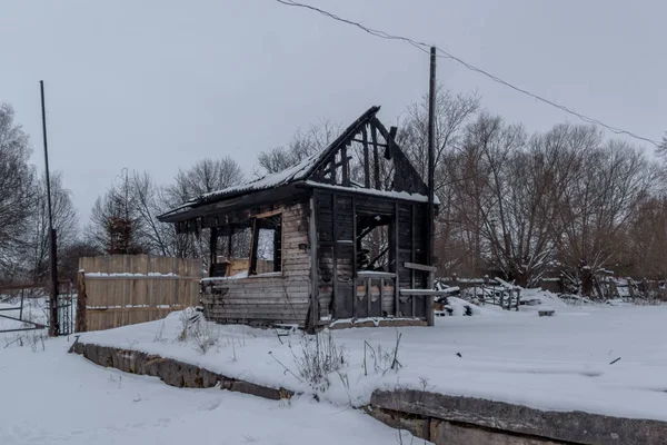 Kış orman yanık küçük ahşap evde akşam görünümü.