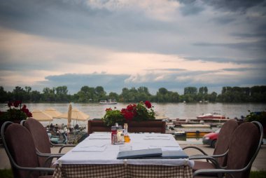 Göllü ve sandalyeli güzel bir restoran manzarası.