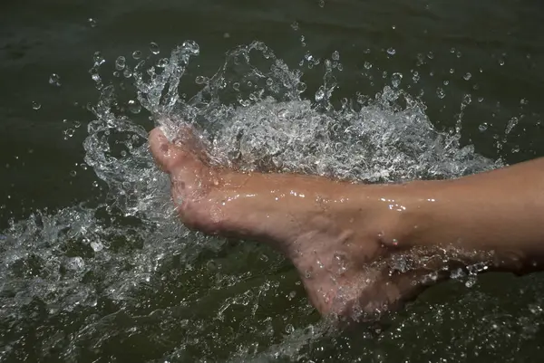 woman feet in water on the beach