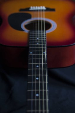 Akustik gitar ve teller. Siyah arkaplanda gitar.