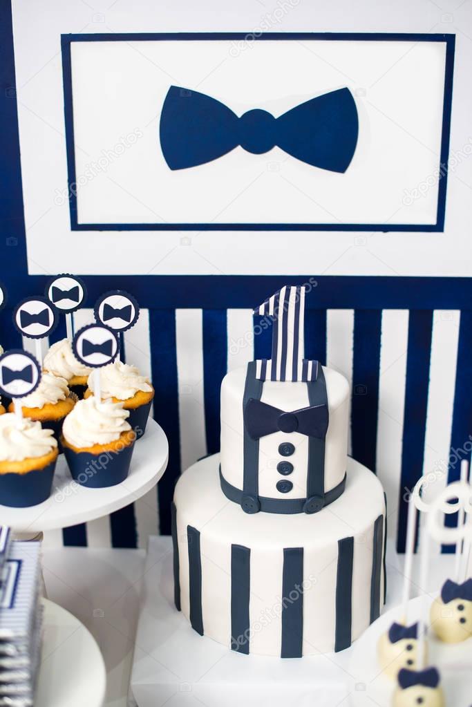 Cake, candies, marshmallows, cakepops, chocolate and other sweets on dessert table at kids birthday party. Birthday Dessert celebration candy bar in white and blue colors.