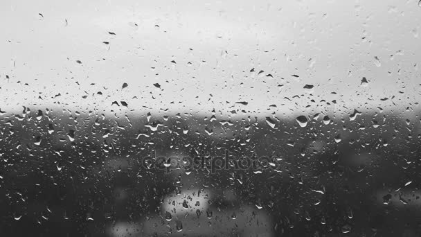 Regentropfen auf einer Fensterscheibe, schwarz-weiß