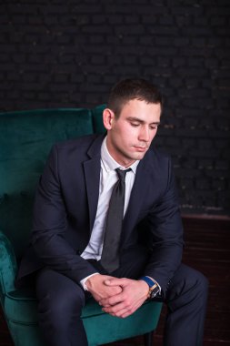 Bir siyah tuğla duvara iş elbiseli yakışıklı adam fotoğraf modeli. Başarılı moda adam