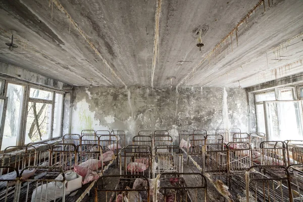 Verlaten kleuterschool in Tsjernobyl uitsluiting Zone. Verloren speelgoed, een kapotte pop. Sfeer van angst en eenzaamheid. Oekraïne, spookstad Pripyat. — Stockfoto