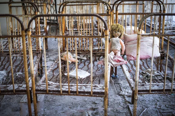 Övergivna förskola i Tjernobyl säkerhetszon. Förlorade leksaker, en trasig docka. Atmosfär av rädsla och ensamhet. Ukraina, spökstad Pripyat. — Stockfoto