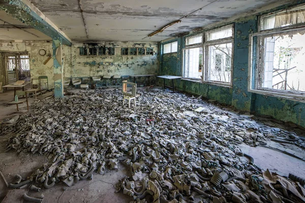 Gasmasker på golvet i mitten skolan i Pripyat, Chernobyl säkerhetszon. Kärnkatastrof — Stockfoto