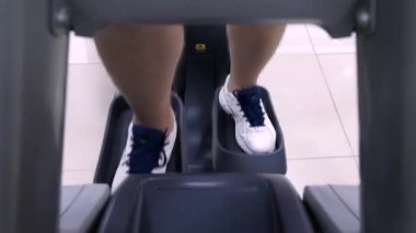 Spor, fitness, yaşam tarzı, teknoloji ve insan kavramı - spor salonunda koşu bandı üzerinde yürüyen adam bacak yakın