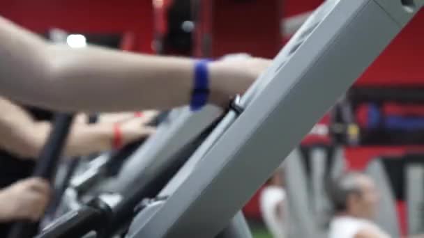 Detail, cvičení na cross trainer stroje v posilovně před tréninkem. Sport a koncept zdravého životního stylu — Stock video
