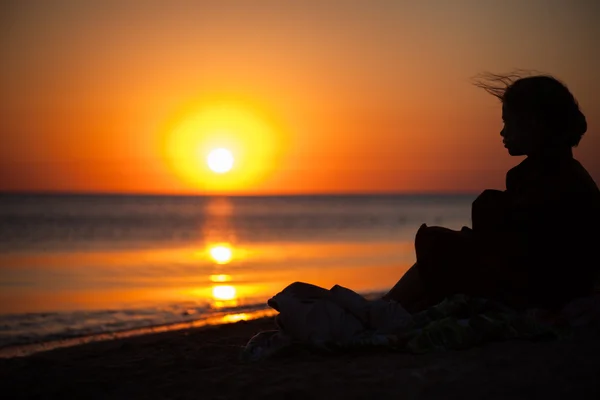 L'enfant regarde le coucher de soleil sur la mer — Photo