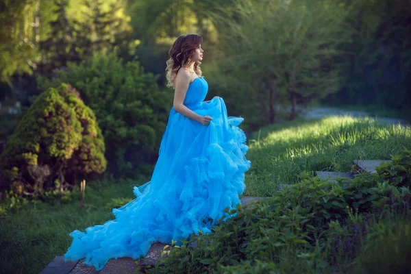 Fiatal gyönyörű lány, egy buja kék ruha — Stock Fotó
