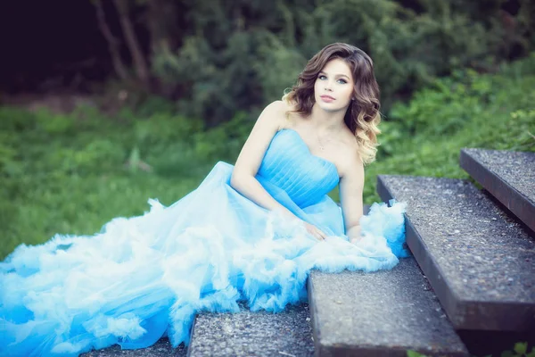 Ung vacker flicka i en grönskande blå klänning — Stockfoto