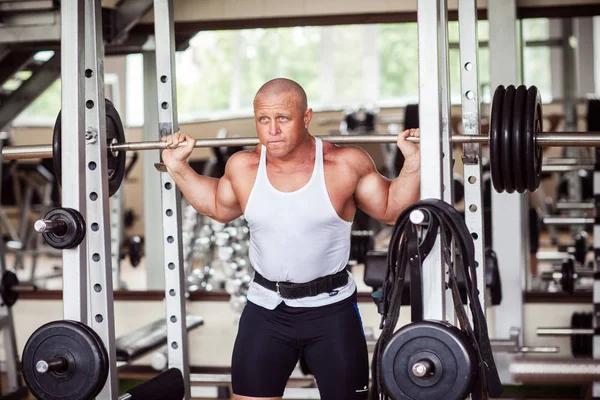 Adam bir halter ile crouches