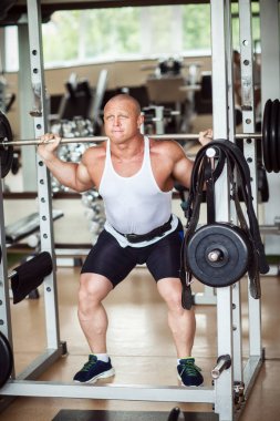 Adam bir halter ile crouches