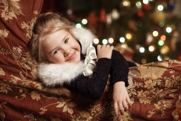 Niño alegre con un regalo cerca del árbol de Navidad — Foto de Stock
