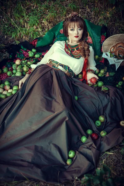 Slavische meisje op het gras met appels — Stockfoto