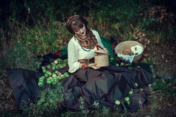 Slavische meisje op het gras met appels — Stockfoto