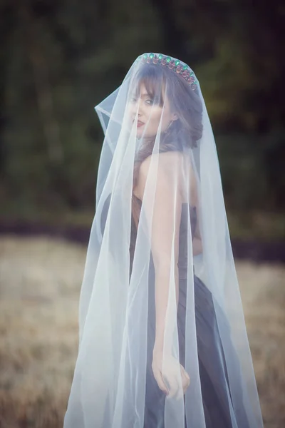 Mulher com um véu no campo — Fotografia de Stock