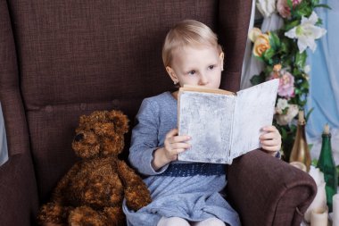 Kız bir sandalyede bir kitap okuma