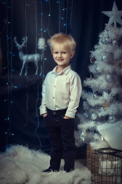 Menino no fundo da árvore de Natal branco — Fotografia de Stock