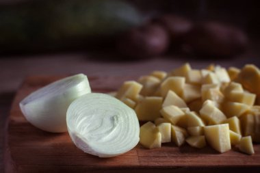 doğranmış soğan ve patates bir kesme tahtası üzerinde