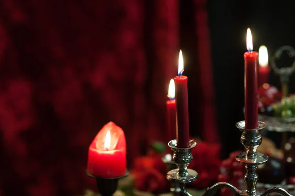 Червоні свічки на червоному оксамитовому фоні — стокове фото