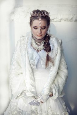 kız beyaz bir arka plan üzerinde bir taç ile beyaz kürk paltolu