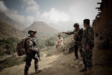 Kabul, Afghanistan - March 10, 2011.Legionnaires in the village with local resident during the military operation. clipart