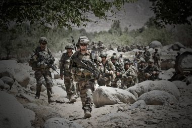 Kabul, Afghanistan - March 14, 2011. Legionnaires study the terrain for further action during a combat mission . clipart