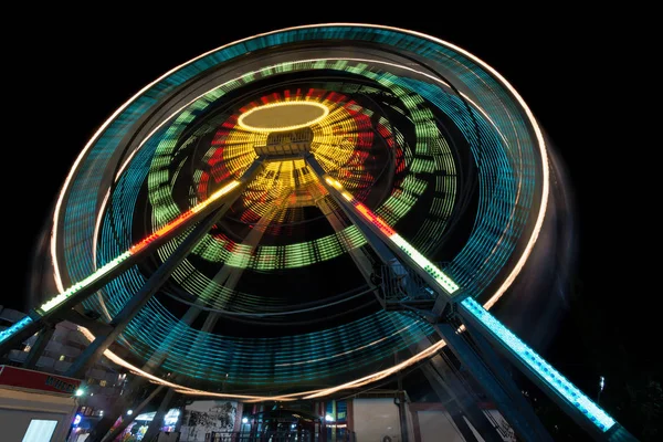 Un beau coup de feu avec une longue exposition la nuit - Grande roue le soir, créant des traînées de lumière — Photo