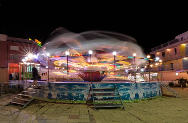 SUNNY BEACH, BULGARIA - 10 de septiembre de 2017: Atracción en el parque. Carrusel en movimiento por la noche. Una foto de larga exposición —  Fotos de Stock