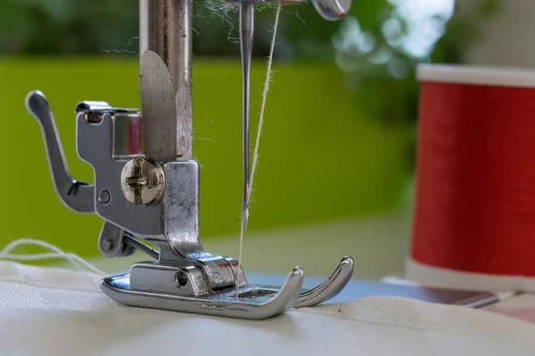 재봉틀의 바늘으로 발 베이지색 색깔 직물 sews. 닫기-최대 — 스톡 사진