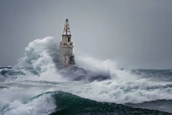 Mercusuar di Stormy Landscape. Gelombang badai melintas mercusuar Ahtopol, Laut Hitam, Bulgaria. Stok Gambar Bebas Royalti