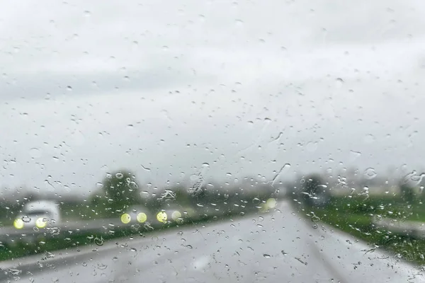 Akşam ları camın ön camına Yağmur Damlaları. şiddetli yağmurda sokak. Bokeh Kuyruk ışığı. yumuşak Odak. Lütfen dikkatli sür, kaygan yoldan. yumuşak odak.