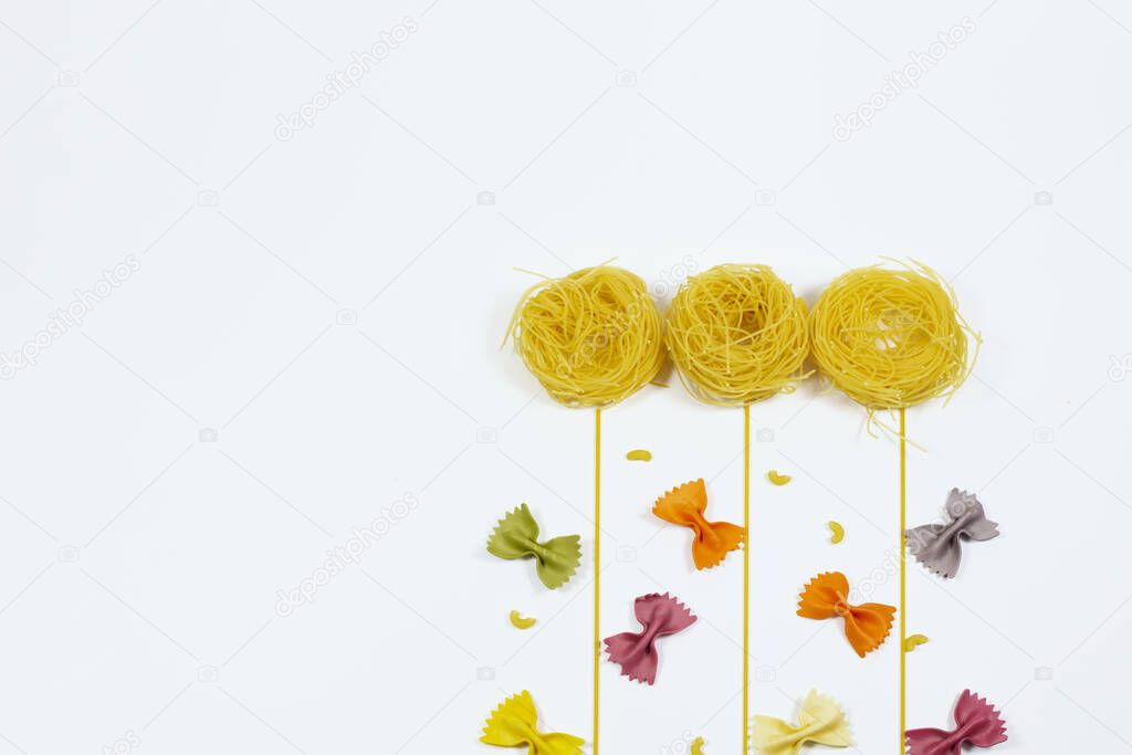 Top view flowers and butterflies made out of various pasta on white background.Copy space, place for text.