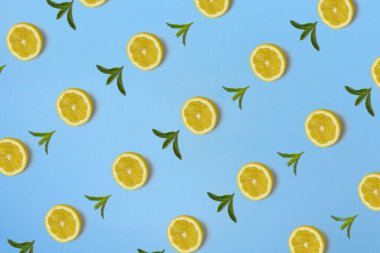 Parlak mavi arka planda sarı limon dilimi ve taze nane yapraklarıyla yapılan son moda güneş ışığı deseni. Asgari yaz konsepti.