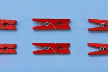 Cyan arka planda küçük kırmızı dekoratif ahşap mandallar. Üst görünüm