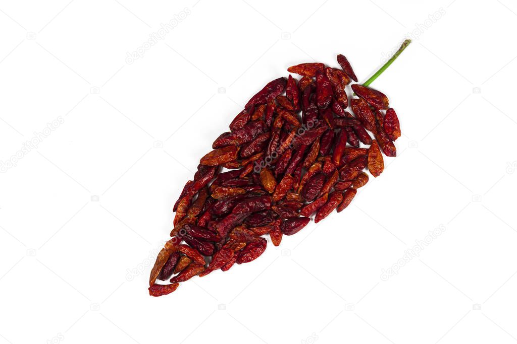 Dry cayenne pepper arranged in the form of a pepper on a white background
