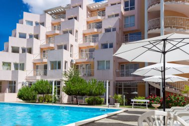 Bulgaristan 'ın Sunny Beach kenti - 05.05.2020: Bulgaristan' ın Karadeniz kıyısındaki en büyük turizm beldesinde yaz mevsimi boyunca sahil kenarındaki şık, rahat ve rahat otel Whit havuzu